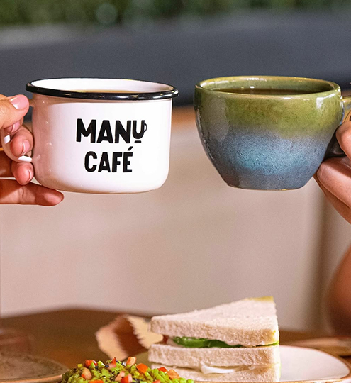 Taza de café caliente preparada en Manu Café